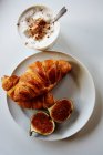 Elevated view of croissants, figs and a cappuccino — Stock Photo