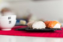 Saboroso nigiri sushi e maki rolos contra fundo turvo — Fotografia de Stock