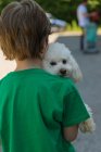 Close-up de menino carregando cão poodle — Fotografia de Stock