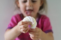 Primo piano di bambina che gioca con un marshmallow — Foto stock