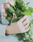 Image recadrée d'une femme tenant un bouquet de roses — Photo de stock
