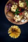 Espaguetis y tabla de cortar con variedad de quesos italianos - foto de stock