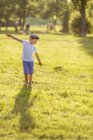 Junge mit Mütze tummelt sich im Park — Stockfoto