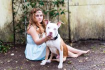 Портрет дівчини-підлітка, що сидить на відкритому повітрі з собакою — стокове фото
