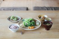 Tasty fresh asian dinner on wooden table — Stock Photo
