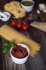 Pasta, pesto, garlic, tomatoes and parmesan on wooden table — Stock Photo