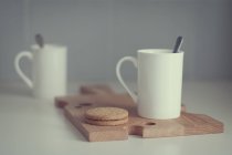 Due tazze di caffè e biscotti sul tagliere. focus selettivo — Foto stock