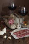 Sliced salami and red wine, vintage style — Stock Photo