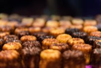 Nahaufnahme von leckeren Canele-Kuchen in Reihen platziert — Stockfoto