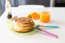 Stack of Pancakes and orange juice on table — Stock Photo
