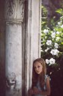 Trauriges Mädchen lehnt Säule im Garten — Stockfoto