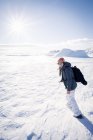Donna che cammina attraverso il paesaggio invernale ghiacciato, Islanda — Foto stock