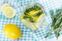 Elevated view of fresh lemonade with rosemary in jar — Stock Photo