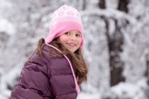Усміхнена дівчина сидить у парку взимку — стокове фото