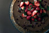 Delicioso bolo de chocolate com morangos frescos no topo — Fotografia de Stock