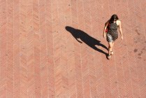 Vue de dessus de la femme marchant le long de la rue — Photo de stock