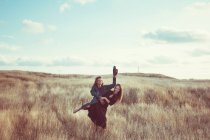 Jovem casal caucasiano brincando no campo — Fotografia de Stock