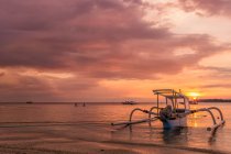 Мальовничий вид на човні на пляжі на захід сонця, Гілі Мено, Індонезія — стокове фото