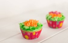 Zwei leckere Cupcakes über Holztisch — Stockfoto