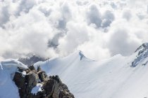 Dos personas caminando a lo largo de Mountain Ridge en los Alpes suizos, Piz Bernina, Graubunden, Suiza - foto de stock