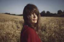 Porträt einer jungen Frau, die auf einem Feld steht — Stockfoto