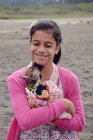 Улыбающаяся девочка-подросток обнимает щенка — стоковое фото