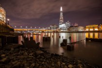 Edificios de la ciudad iluminados por la noche, Thames River, Londres, Reino Unido - foto de stock