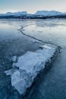 Suecia, Laponia, Lago congelado de Tornetrask con grieta que conduce a la montaña de Lapporten - foto de stock