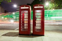 Lichtwege und rote Telefonzellen, London, England, Großbritannien — Stockfoto