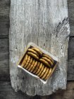 Caixa de biscoitos de milho na prancha de madeira, vista superior — Fotografia de Stock
