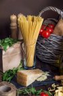 Pasta, parmesan, rocket and tomatoes, rural kitchen concept — Stock Photo