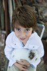 Retrato de Sorrindo menino segurando coelho de estimação fofo — Fotografia de Stock