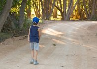 Мальчик идет по дороге в сельской местности — стоковое фото