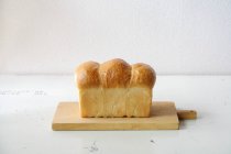 Pane di pane appena sfornato sul tagliere di legno — Foto stock