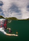 Mujer buceando bajo el agua buscando una medusa - foto de stock