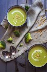 Bowls of hot green broccoli soup, top view — Stock Photo