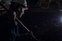 Nahaufnahme eines männlichen Bergarbeiters, der in einem Kohlebergwerk mit Schaufel arbeitet — Stockfoto