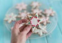 Main féminine tenant un cookie en forme d'étoile — Photo de stock