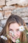 Portrait of smiling girl with daisy flowers — Stock Photo