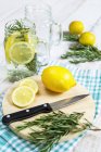 Fresh lemonade with rosemary over wooden table — Stock Photo