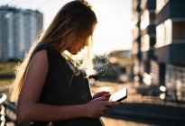 Frau lehnt mit digitalem Tablet im Freien an Wand — Stockfoto