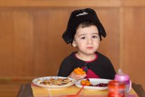 Boy eating breakfast dressed as pirate — Stock Photo