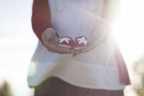 Cropped image of Pregnant woman holding small baby shoes — Stock Photo