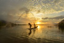 Silhouette d'un homme jetant un filet de pêche, rivière Mékong, Sangkhom, Thaïlande — Photo de stock