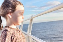 Bambina in piedi sulla barca e guardando il mare — Foto stock