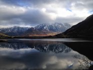 Reflexão de uma montanha coberta de neve em um lago perto de Dornie, Escócia — Fotografia de Stock