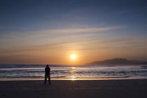 Silhueta de homem em pé na praia ao pôr do sol, Tarifa, Andaluzia, Espanha — Fotografia de Stock