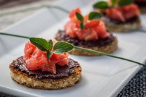 Tomato and olive tasty bruschetta in white plate — Stock Photo