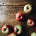 Manzanas frescas maduras en una mesa de madera, vista superior - foto de stock