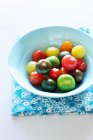 Green, orange and red tomatoes in a bowl — Stock Photo